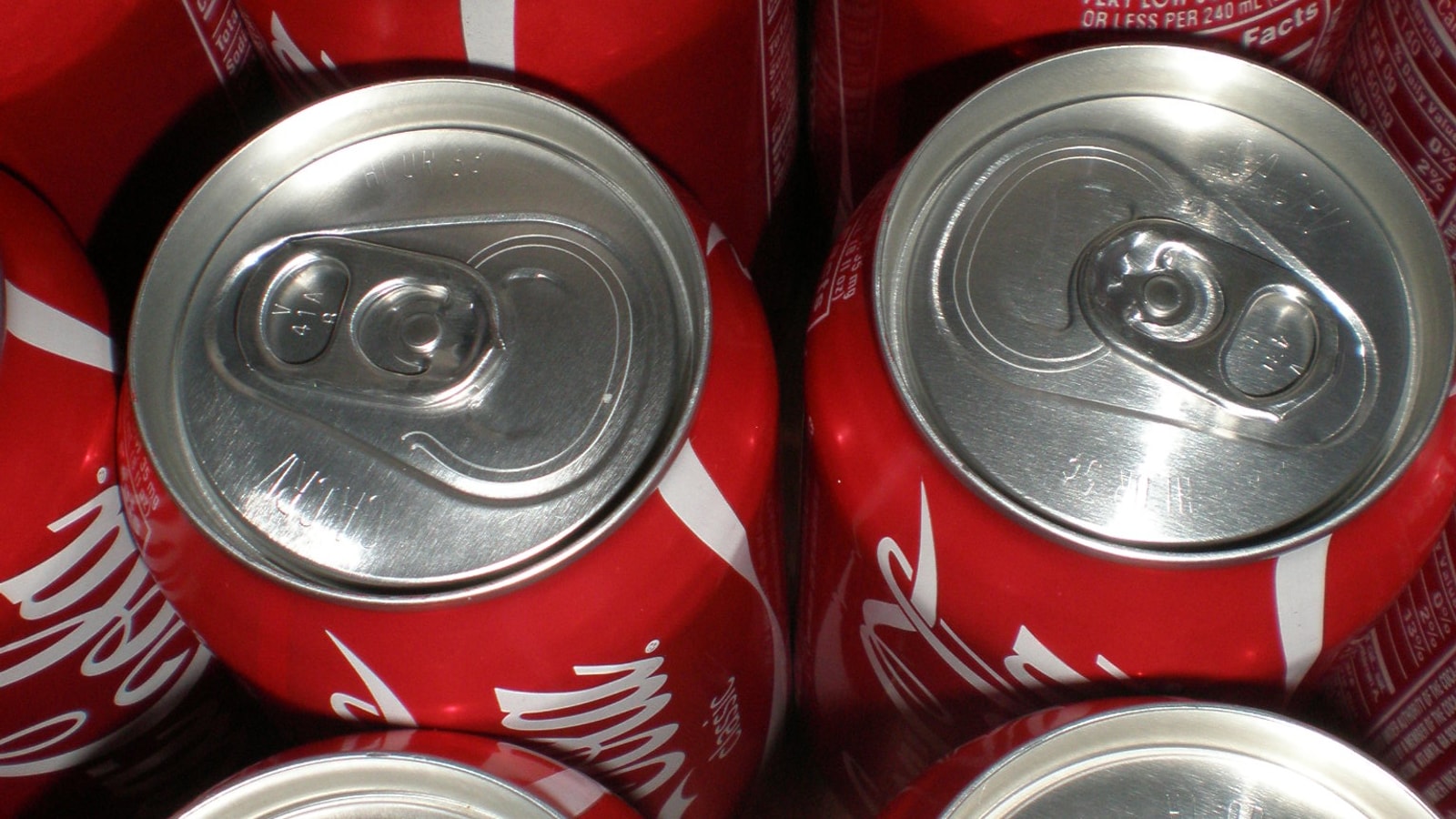 Case of Coca-Cola cans viewed from above.