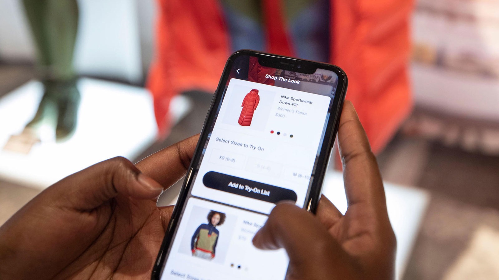Official Nike photograph of a shopper using a Nike connected retail experience on a phone inside a store.