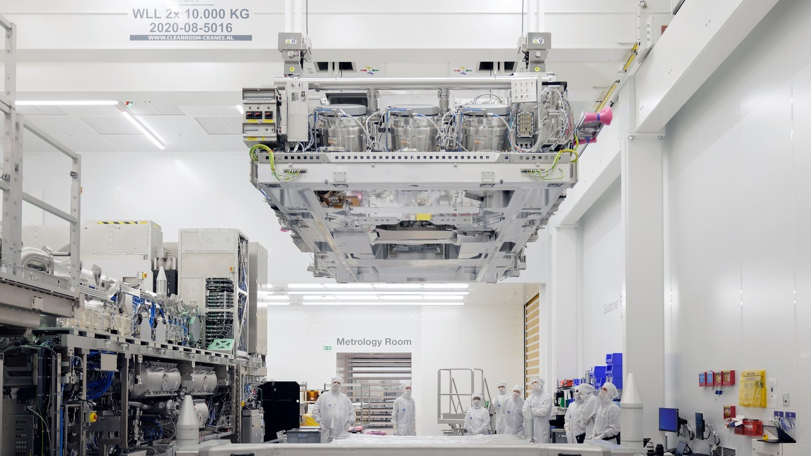 An ASML High-NA top module being lifted during assembly in a Veldhoven cleanroom.