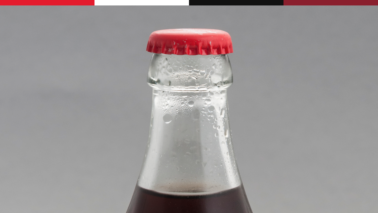 Coca-Cola glass bottle crop showing cold condensation and contour shape.