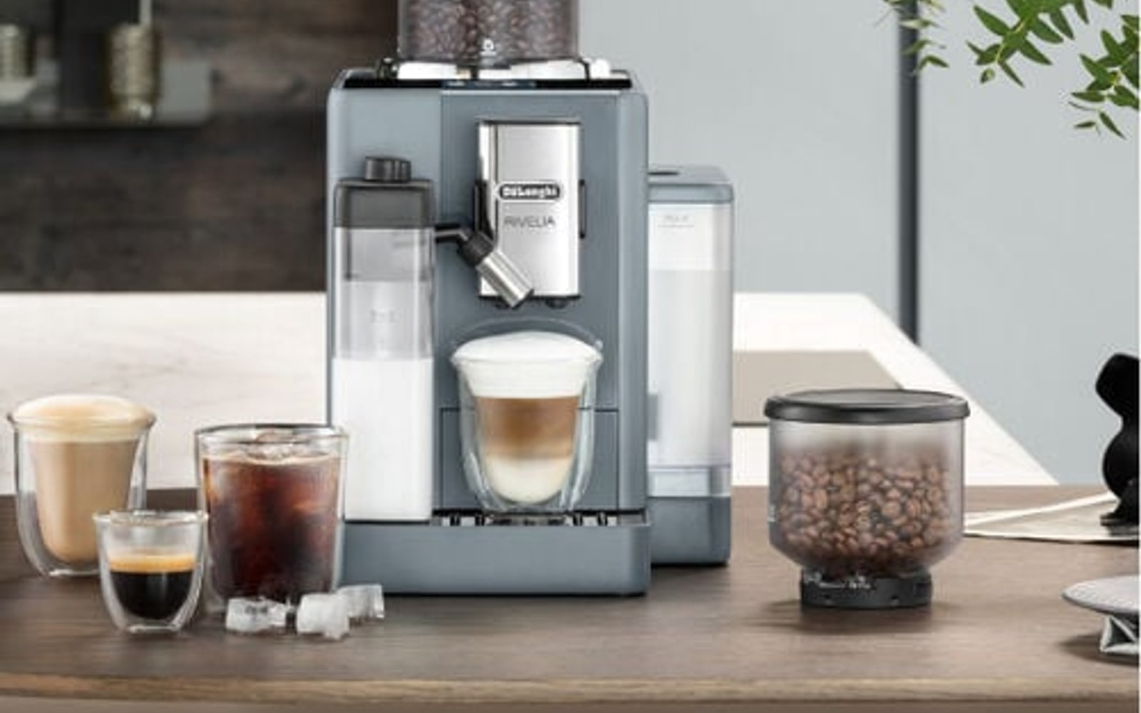 DeLonghi espresso machine with coffee cups and kitchen counter setting.