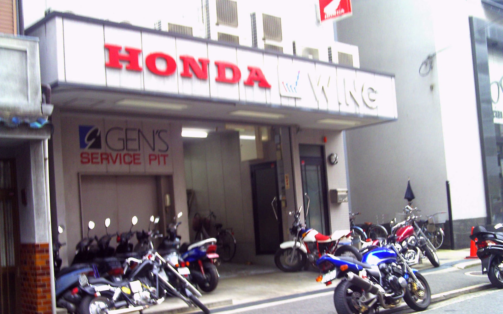 Honda motorcycle shop with Honda signage and motorcycles visible at street level.