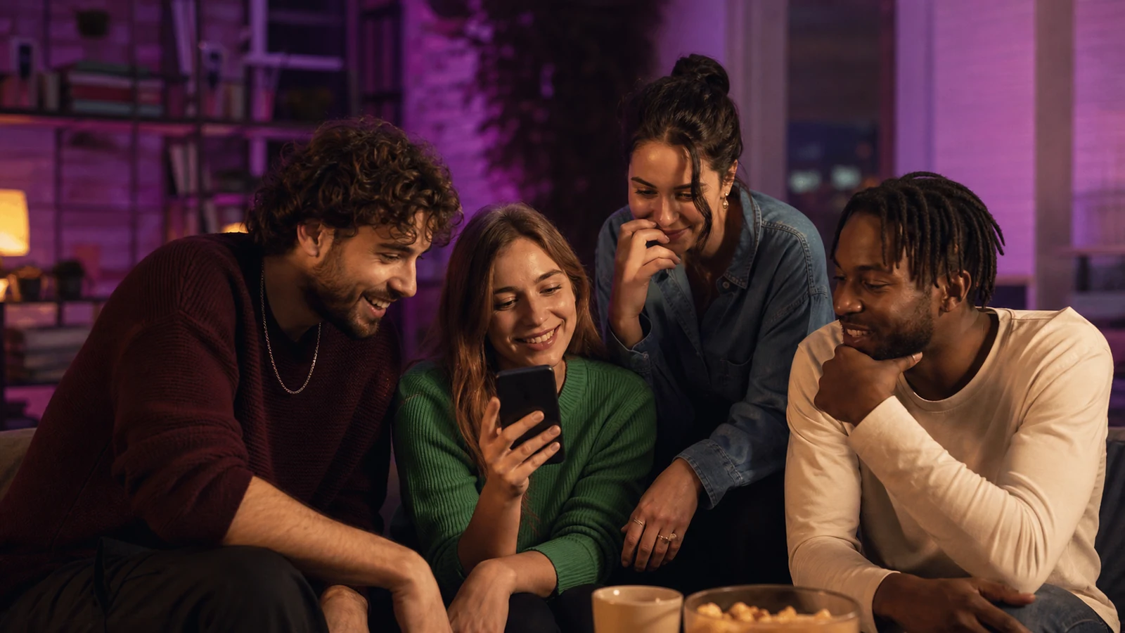 Friends share and react to a short video from one phone in a city apartment.