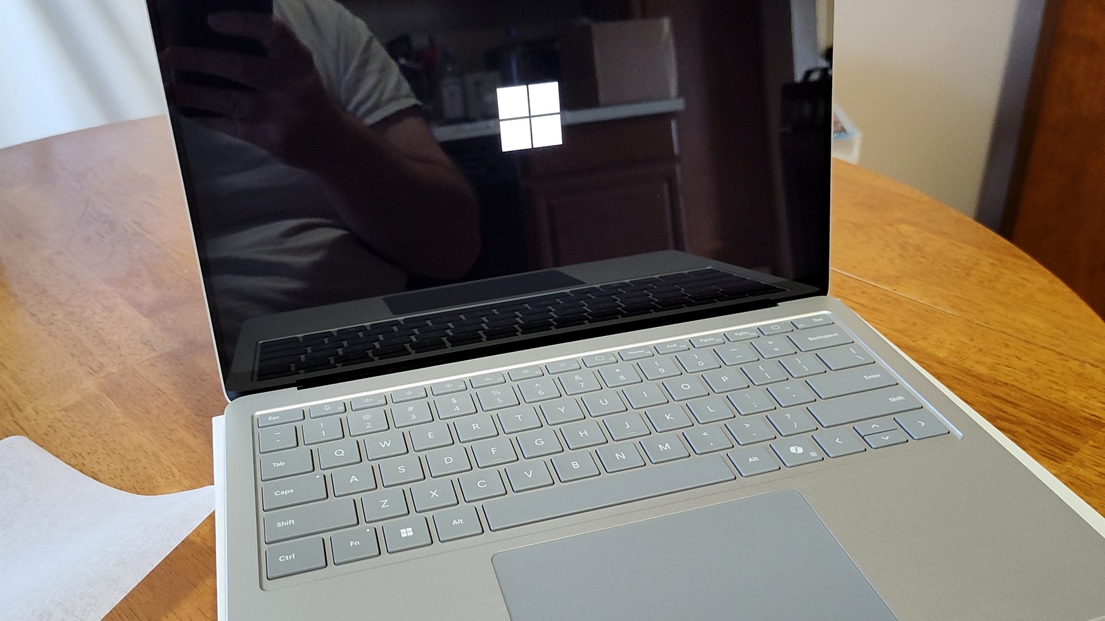 Microsoft Surface laptop on a table with Windows hardware visible.