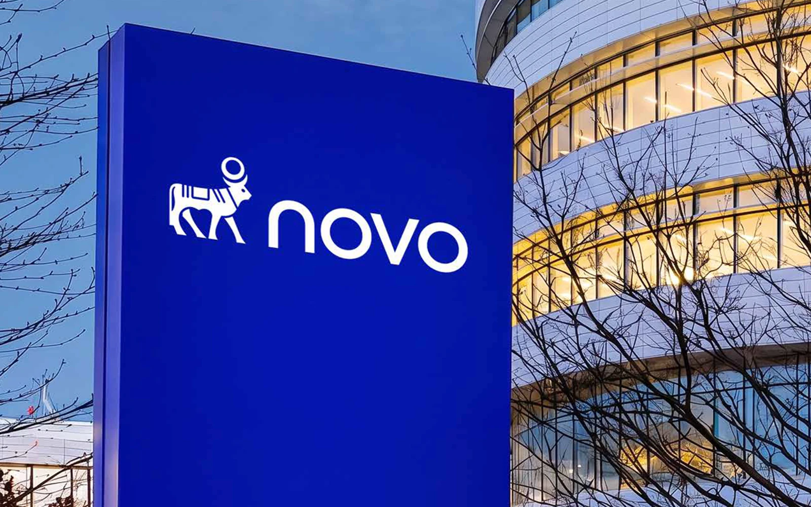 Official Novo launch image showing the new right-facing Apis and Novo wordmark on a blue sign outside company offices.