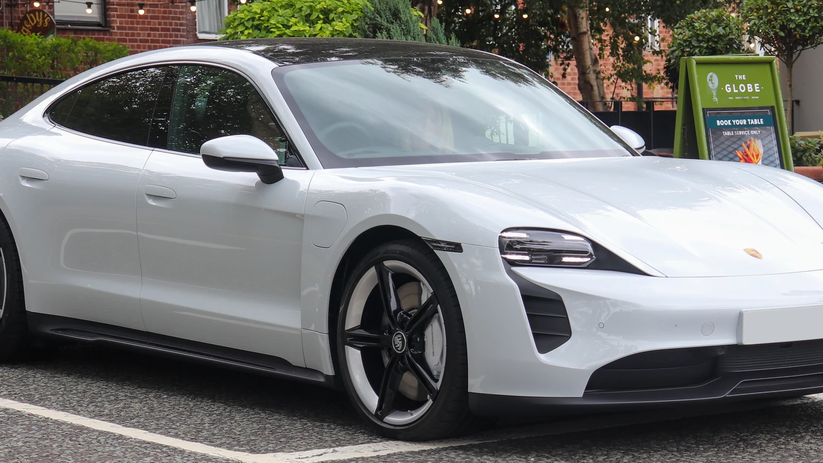 White Porsche Taycan photographed in everyday city use.