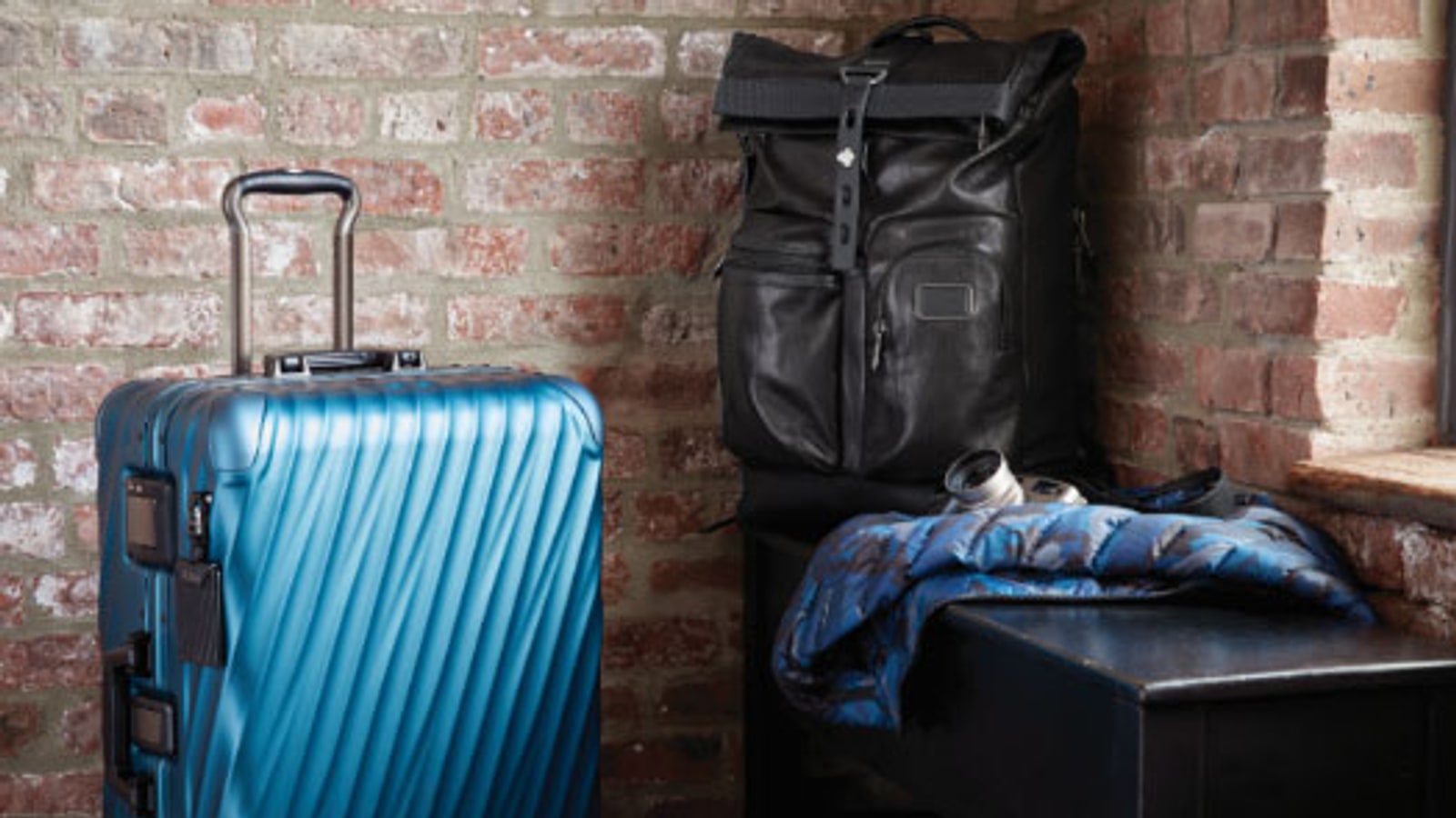TUMI luggage and travel bag scene with premium materials.