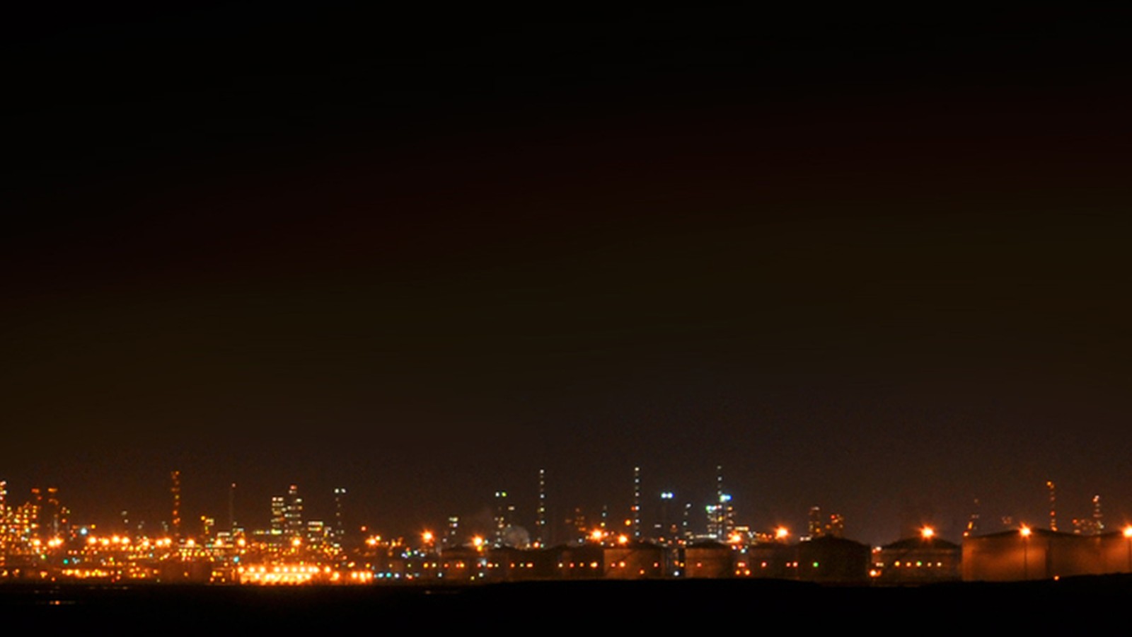 SATORP refinery night view with industrial lights and plant scale visible.
