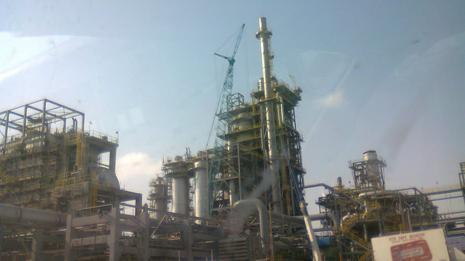 Large refinery structures in Jubail with industrial pipes and towers visible.