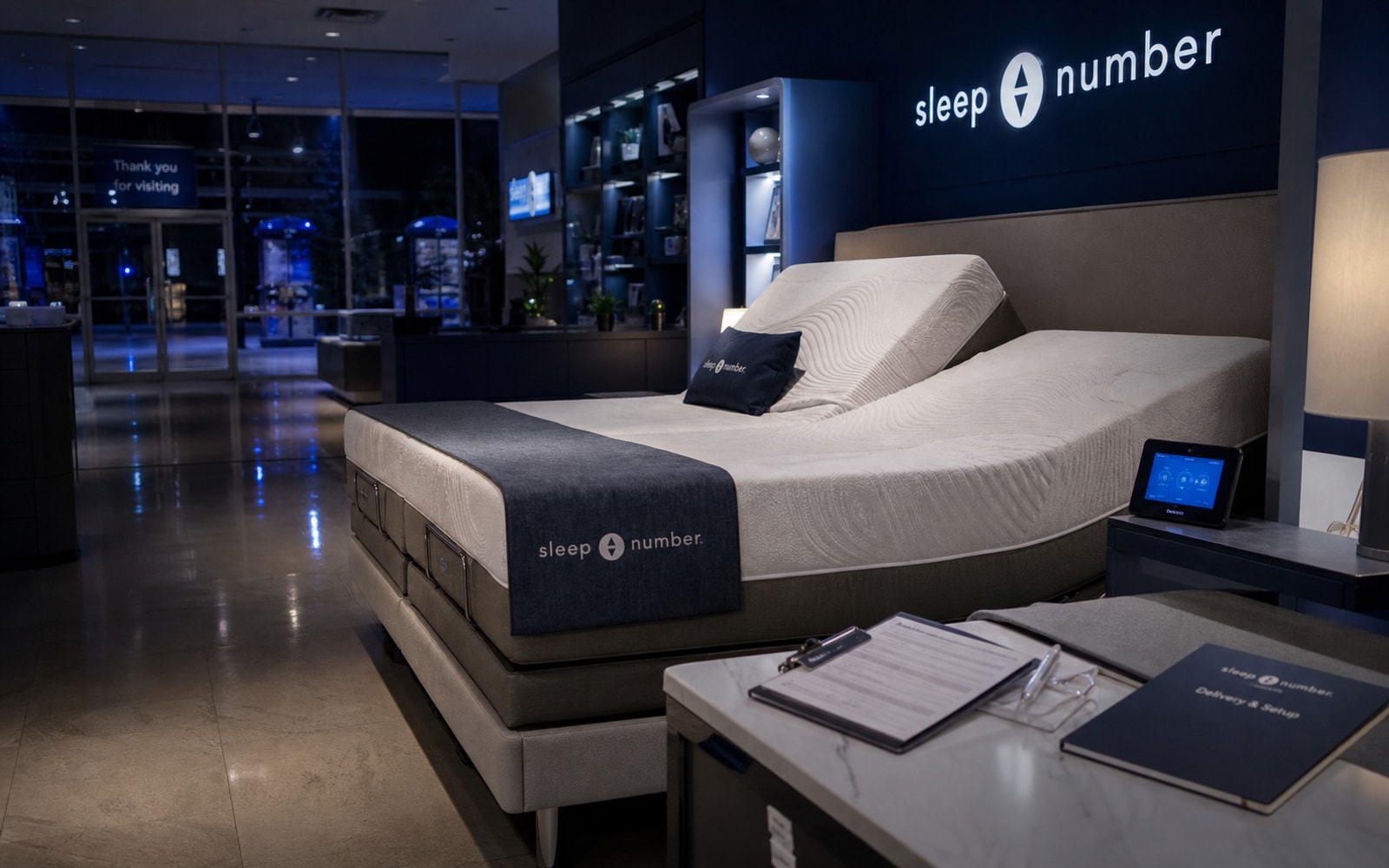 A realistic Sleep Number-style showroom and smart-bed sale-process scene with blue retail cues, financing paperwork, and store equipment.