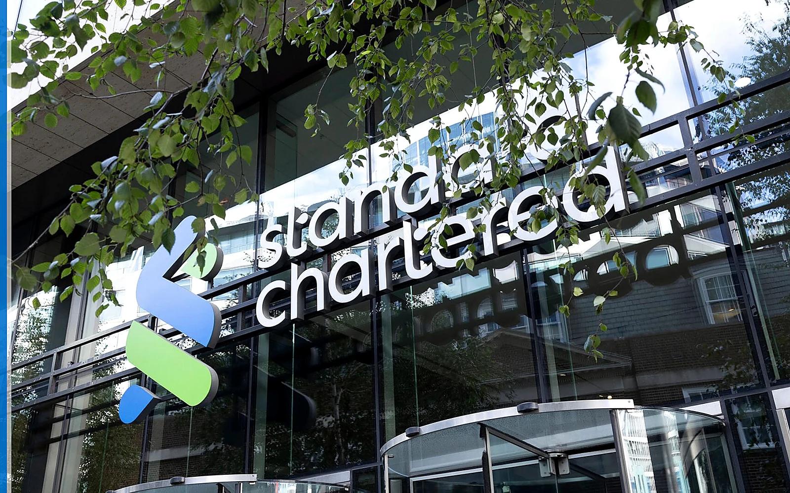 Standard Chartered banking service scene with the source-backed mark in a cross-border financial setting.