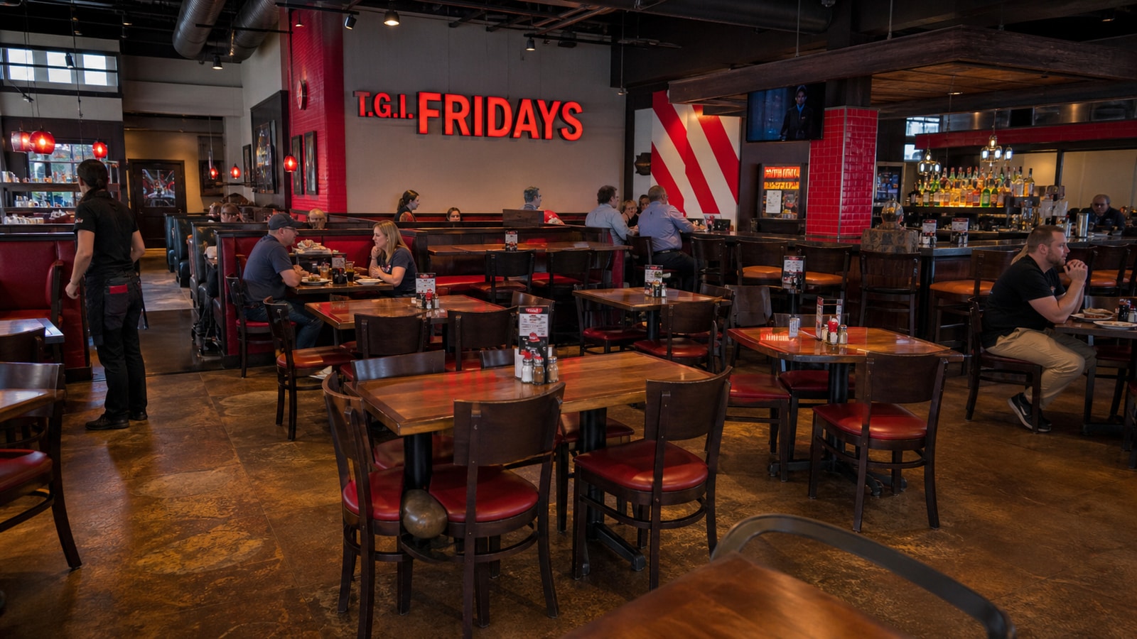 Active TGI Fridays dining room during a soft midweek service with many open tables.