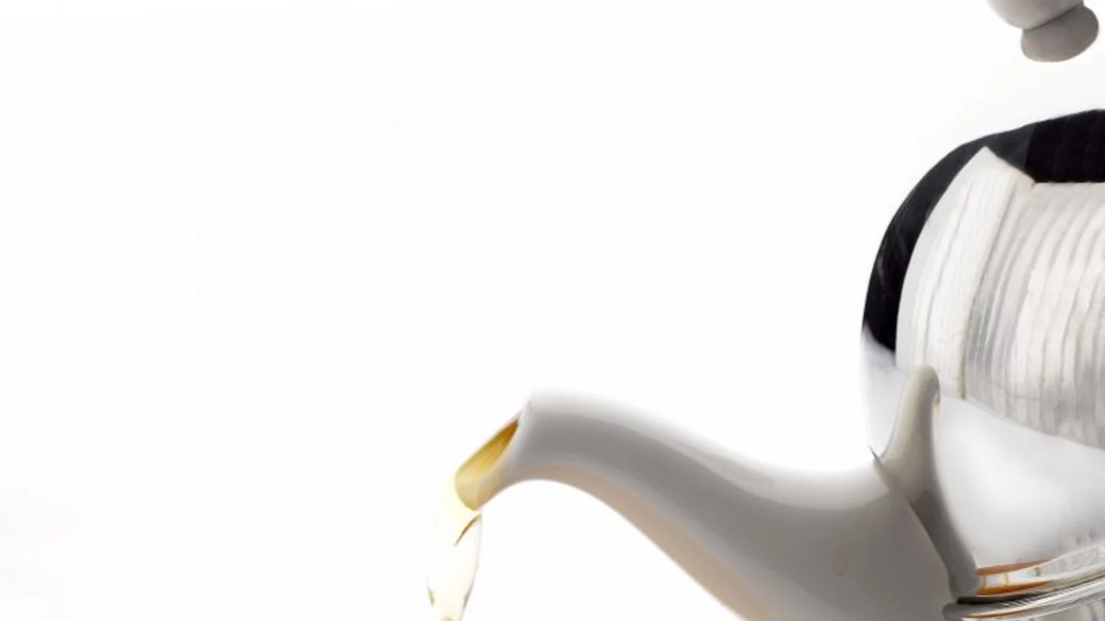 White teapot pouring tea in a restrained service setting.