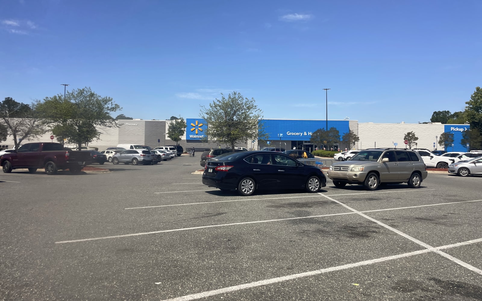 Walmart Supercenter exterior with the blue Walmart sign, parking field, and large-format retail scale visible.