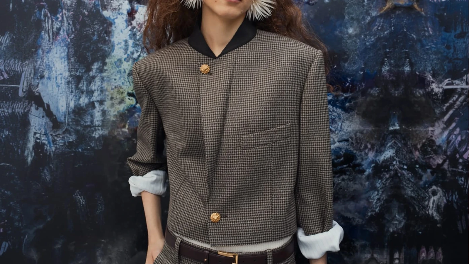 Detail of a Chanel Spring/Summer 2026 checked jacket with a dark collar and gold-tone buttons.