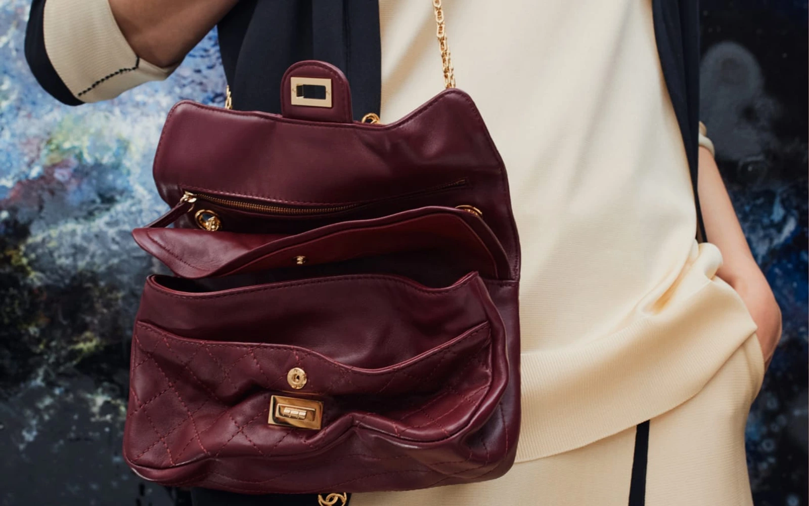Open quilted Chanel handbag with chain and metal turnlock, photographed with a Spring/Summer 2026 outfit.