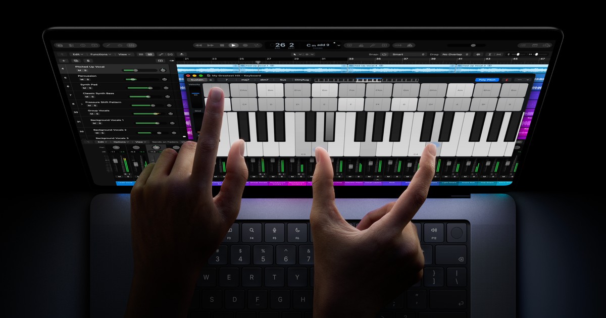 Hands use the touchscreen keyboard in Logic Pro on a MacBook Pro with PROLED XDR Display.