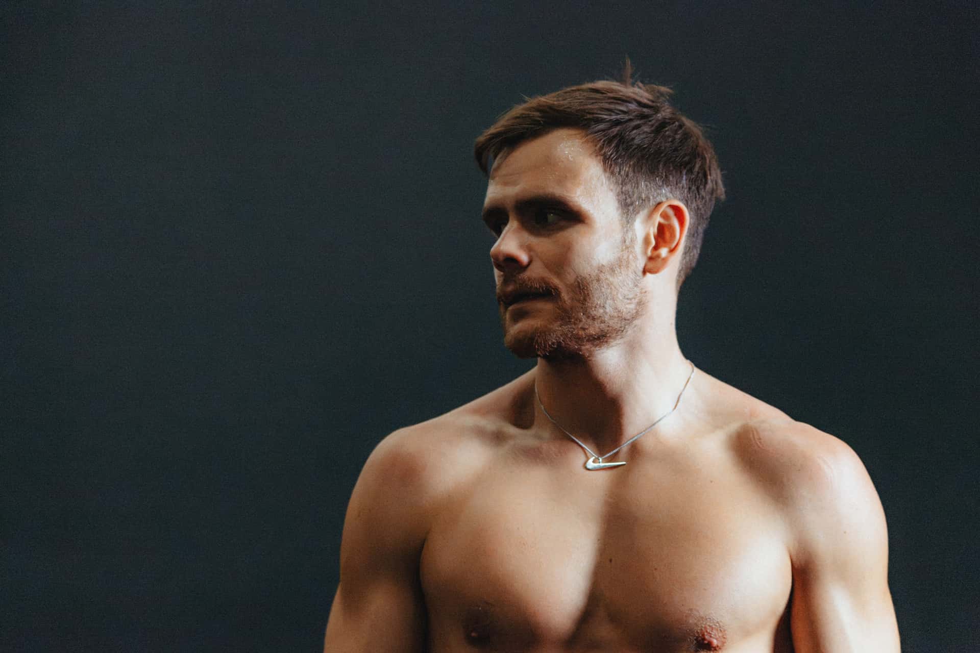 Tim Wenisch wearing a Nike Swoosh necklace in an official Nike portrait.