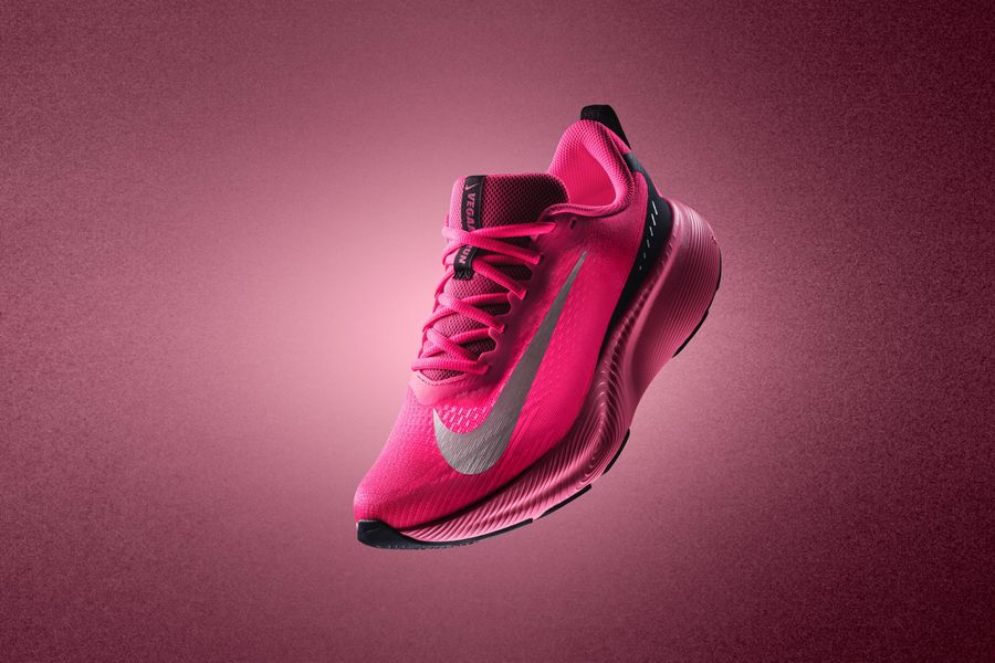 Bright pink Nike Vegam Run shoe against a pink background.