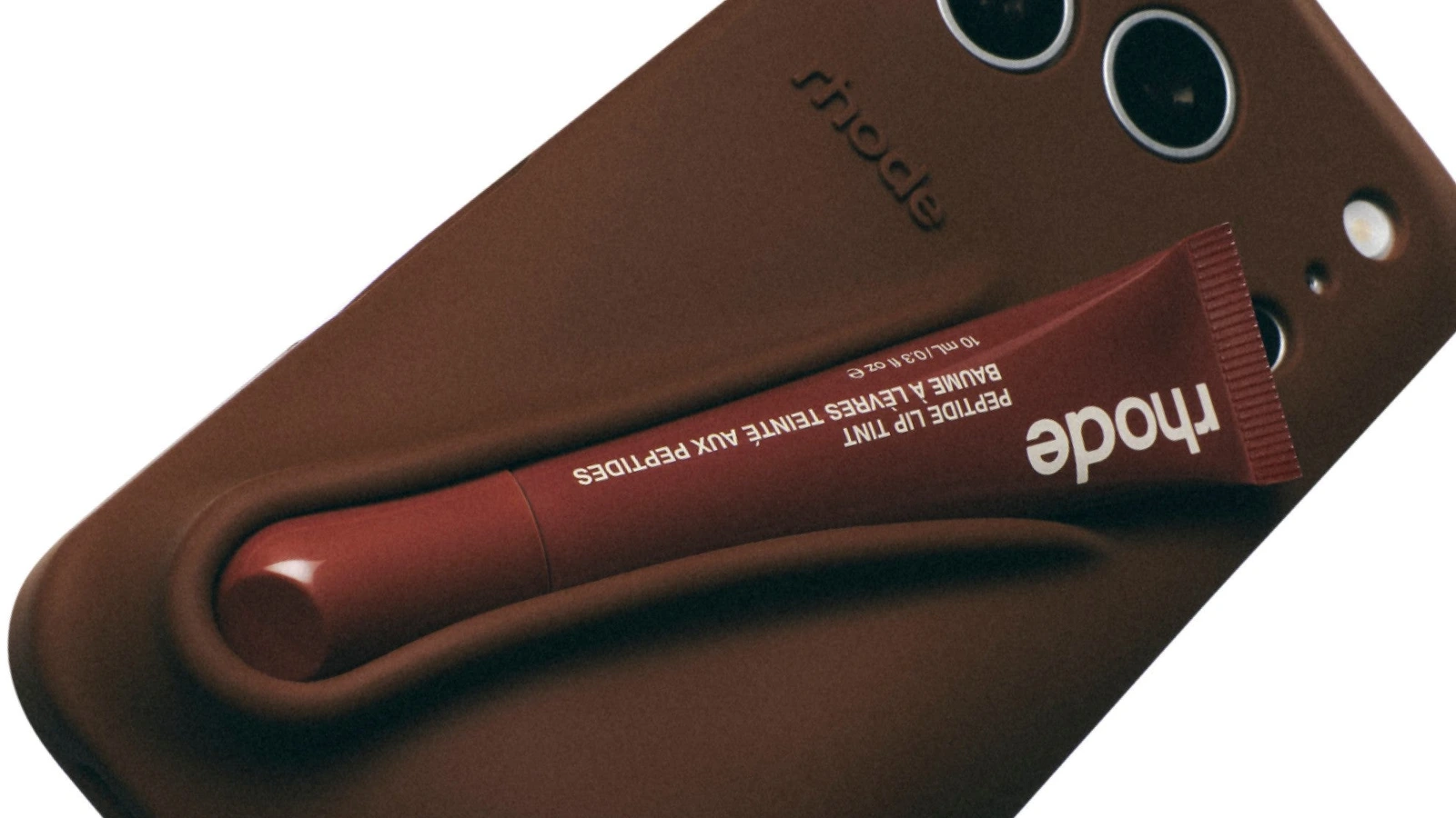 Detail of a bronze Rhode Lip Case with a Peptide Lip Tint tube held in its shaped recess.