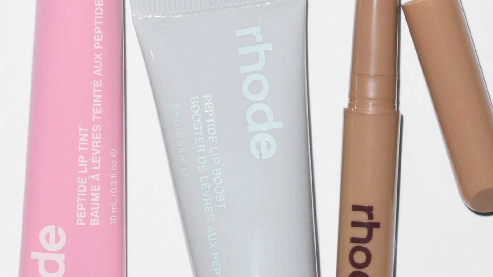 Close detail of Rhode Peptide Lip Tint, Peptide Lip Boost and Peptide Lip Shape packaging.
