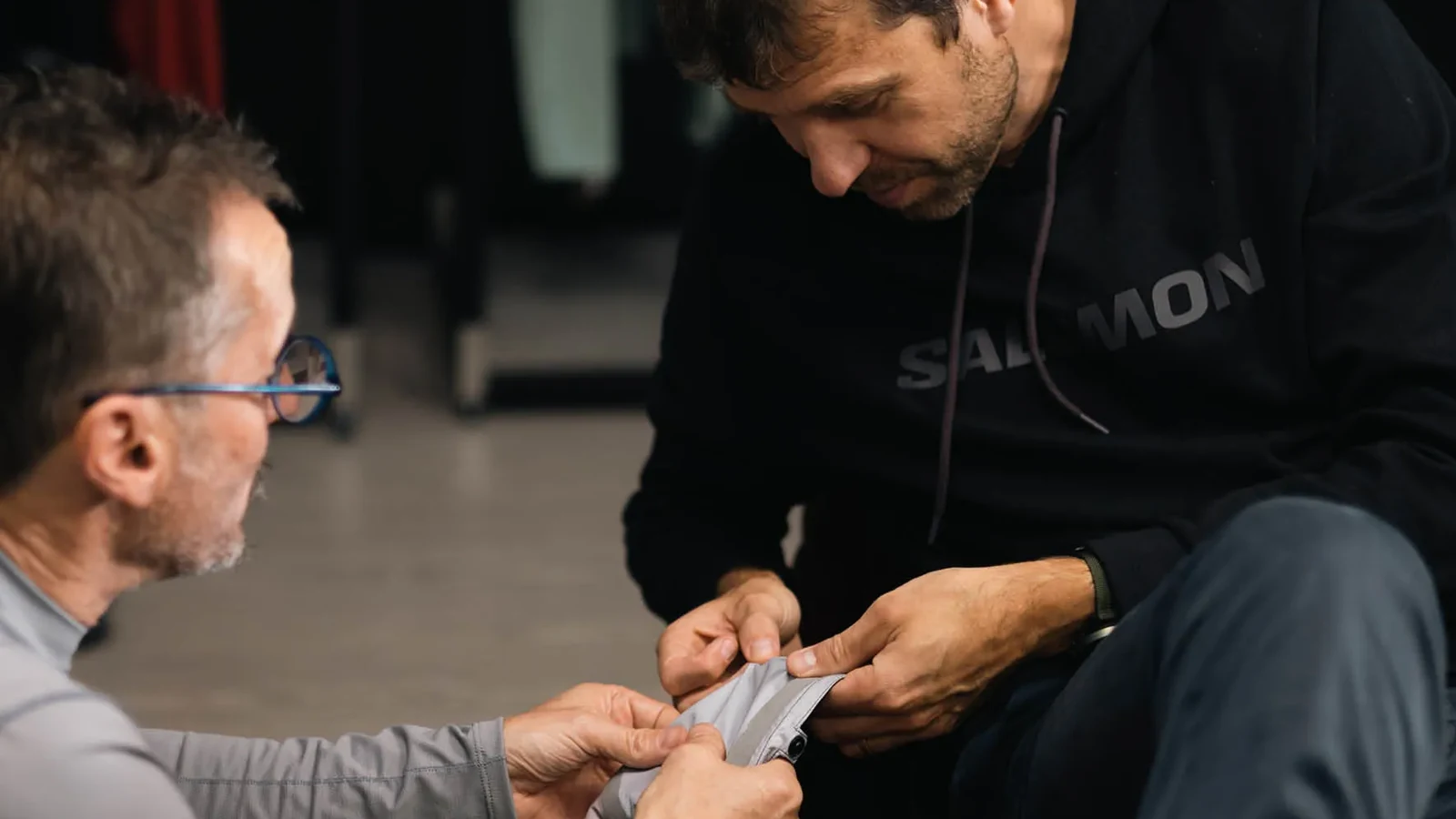 Two designers examining a Salomon trail shoe during co-design.