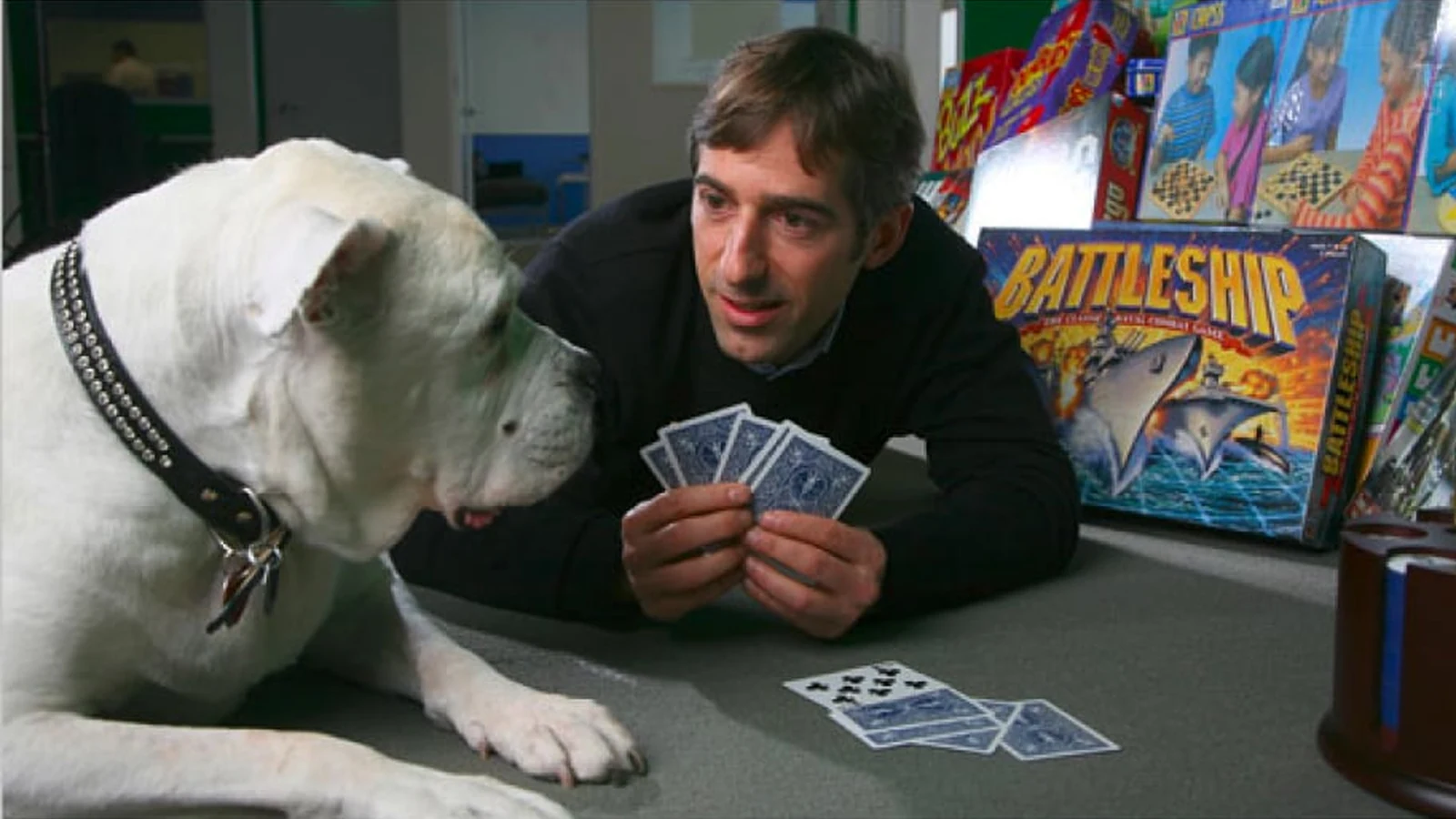 Zynga founder Mark Pincus playing cards beside Zinga, the bulldog that gave the company its name.