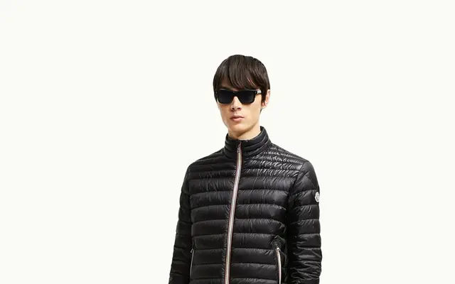 Moncler brand page hero proof surface showing outerwear, badge recognition, and group architecture.