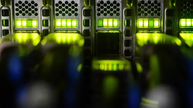 Server rack detail with green-lit data center equipment.