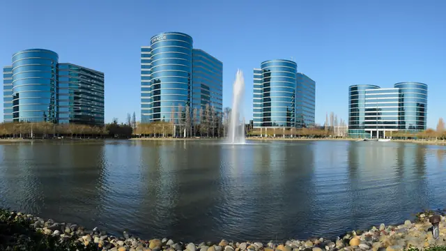 Oracle Redwood Shores campus buildings reflected across the lagoon.