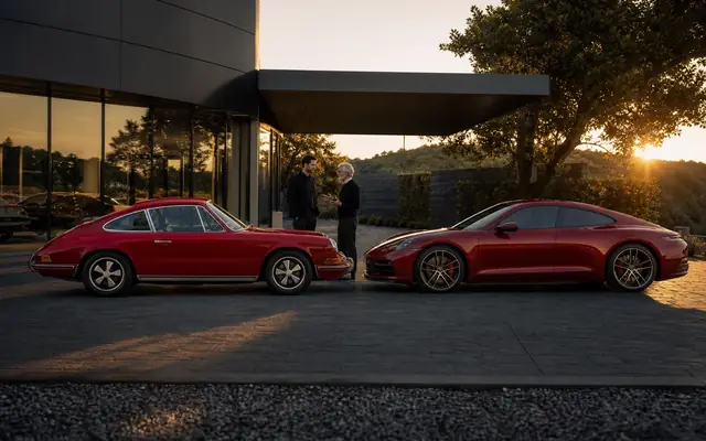 Story-led Porsche parking-court scene with a classic 911 beside a newest-generation Porsche sports car, showing old cult memory next to current desirability.