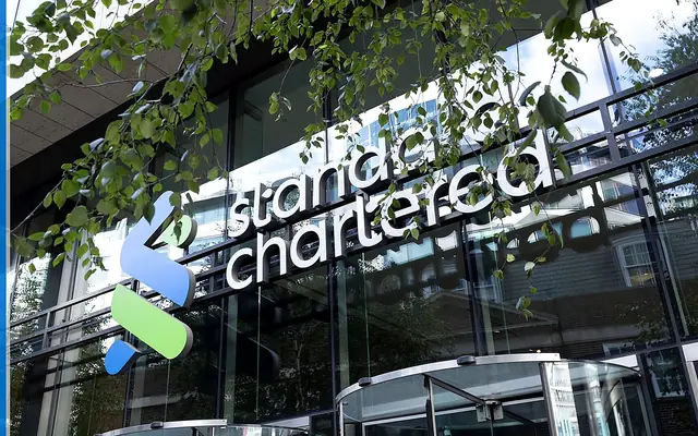 Standard Chartered banking service scene with the source-backed mark in a cross-border financial setting.